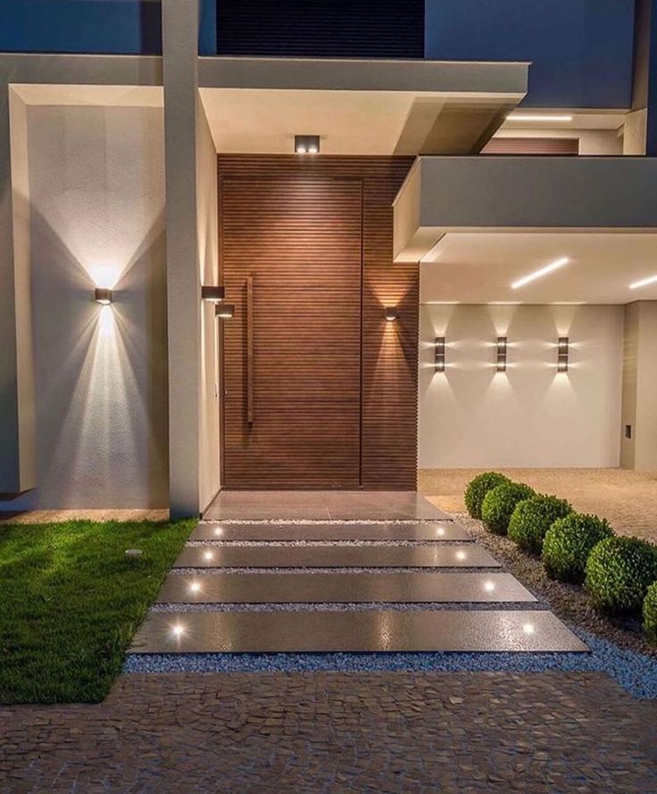 a modern house with lights on the front door