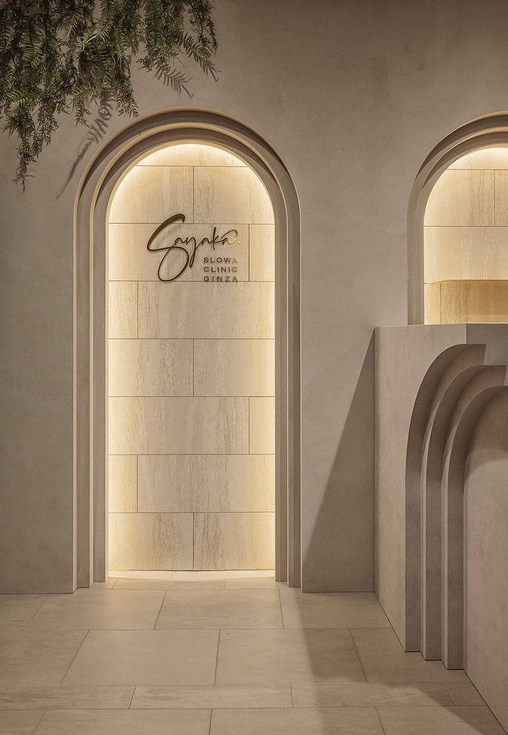 the entrance to an upscale hotel with arched doorways and stone walls, illuminated by lights