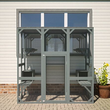 an open door on the side of a building with plants and potted plants in it