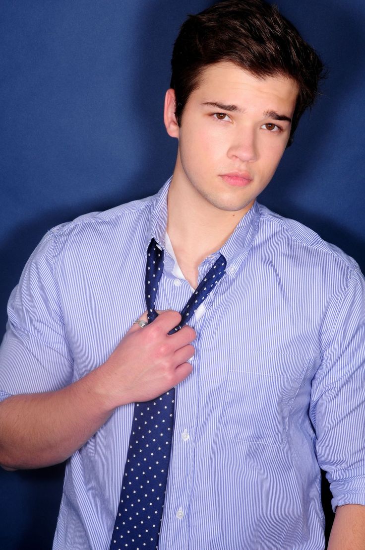 a young man wearing a blue shirt and tie