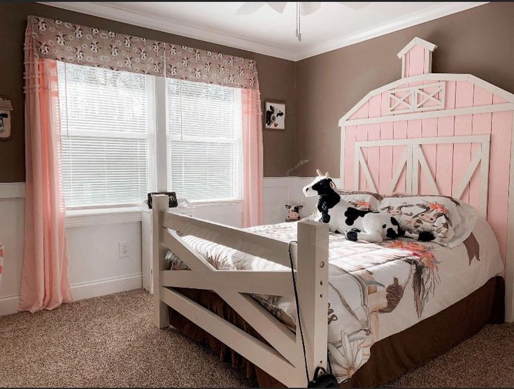 a child's bedroom with pink and brown walls, white bedding and curtains