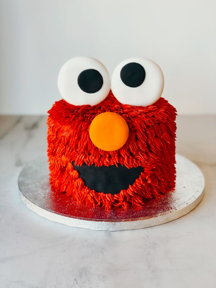 the cake is decorated with red icing and has eyes on it's face