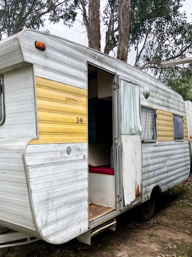 an old camper trailer with the door open