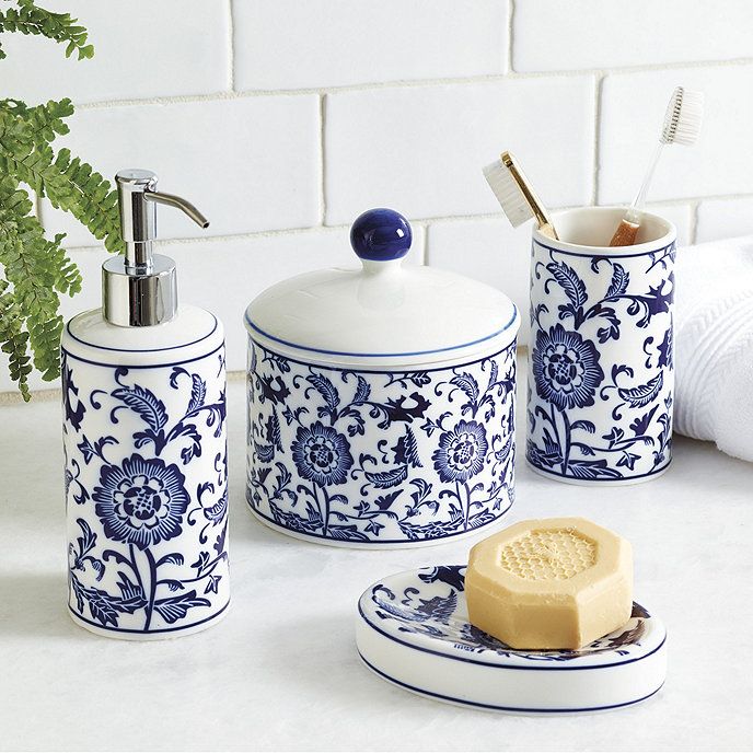 blue and white bathroom accessories on counter next to potted plant, soap dispenser