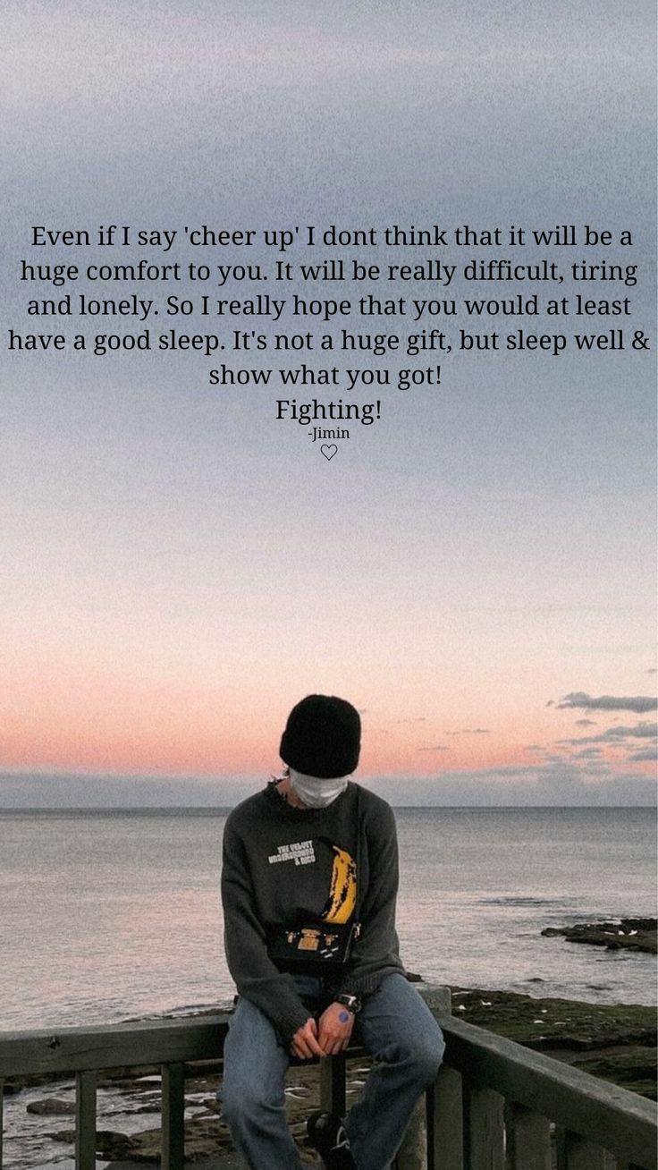 a man sitting on top of a wooden railing next to the ocean with a quote