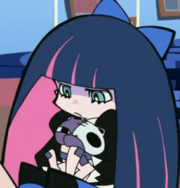 an anime character with long blue hair holding a stuffed animal in her lap and looking at the camera