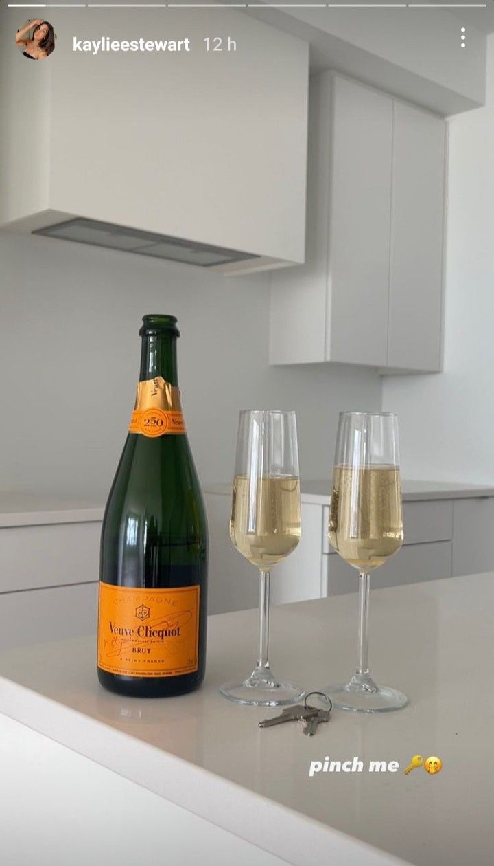 two wine glasses and a bottle on a counter