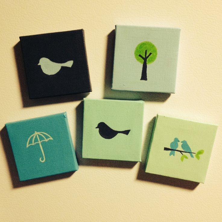 four square magnets with birds and an umbrella painted on them, all in different colors