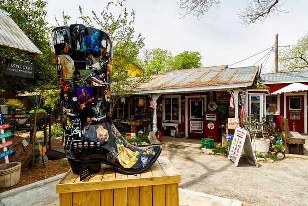 there is a statue made out of shoes on display in front of a storefront