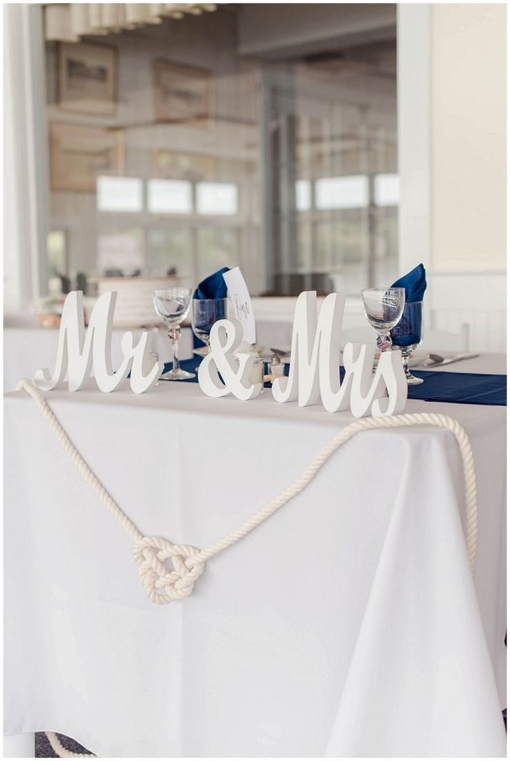 the mr and mrs sign is sitting on top of a table with white linens