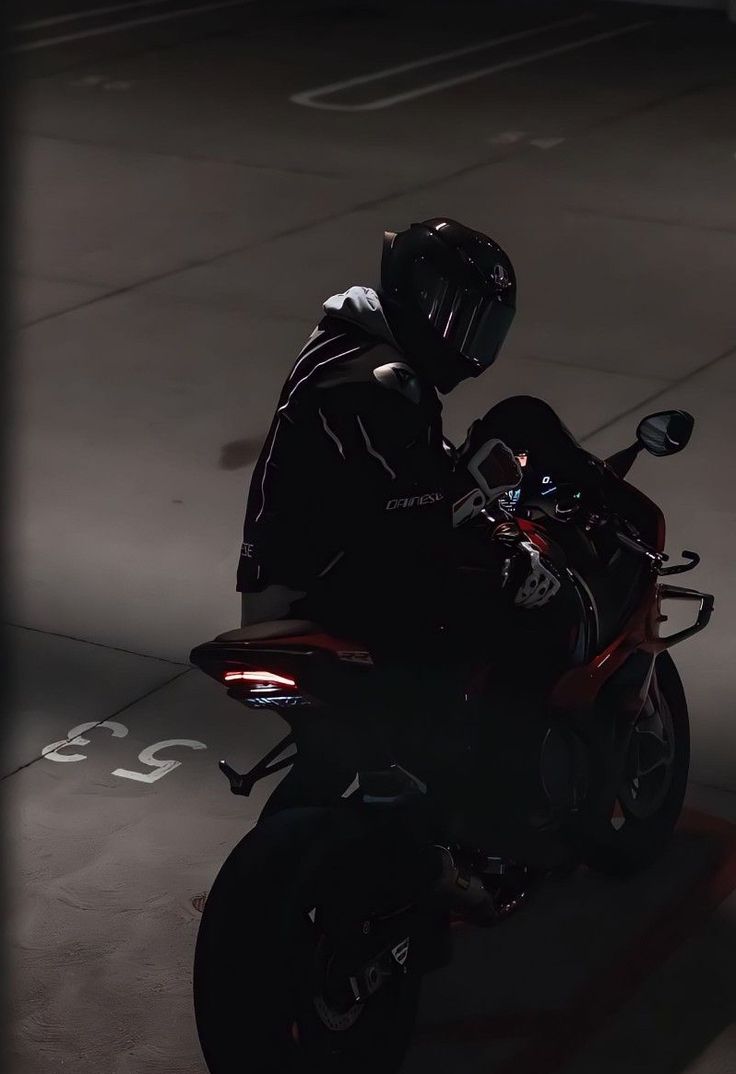 a man riding on the back of a red motorcycle