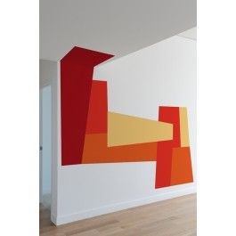 an abstract painting on the wall in a room with wood flooring and white walls