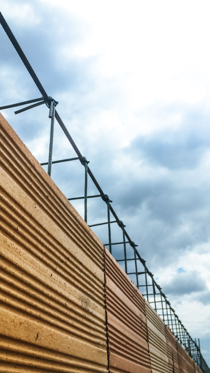 a close up view of a wooden wall and metal railings on a cloudy day