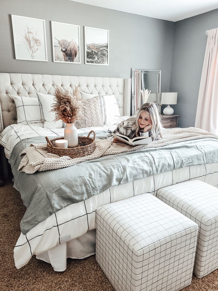 a woman laying on top of a bed next to a footstool and ottoman