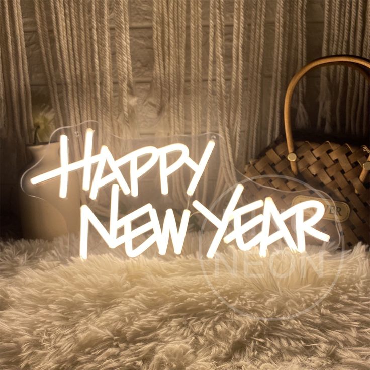 a happy new year neon sign sitting on top of a furry rug next to a purse