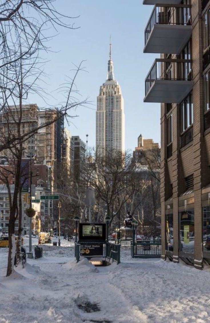 a city street covered in snow with tall buildings