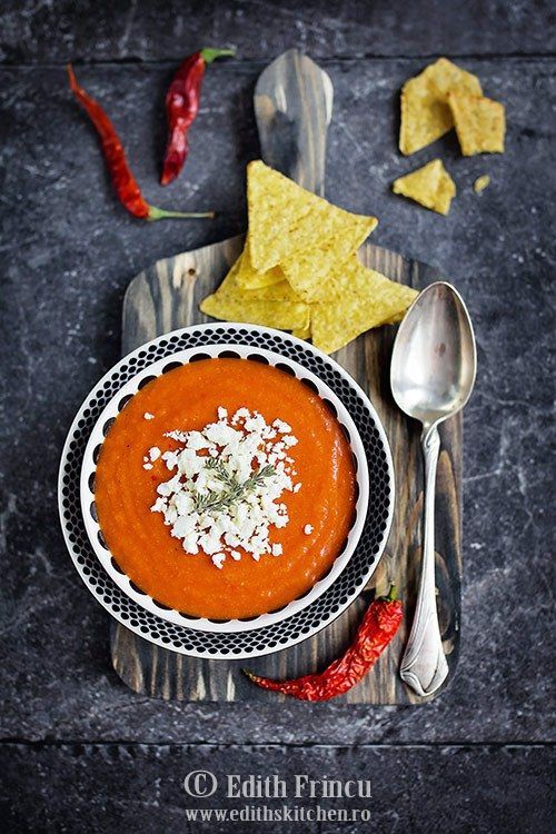 a bowl of tomato soup with tortilla chips on the side