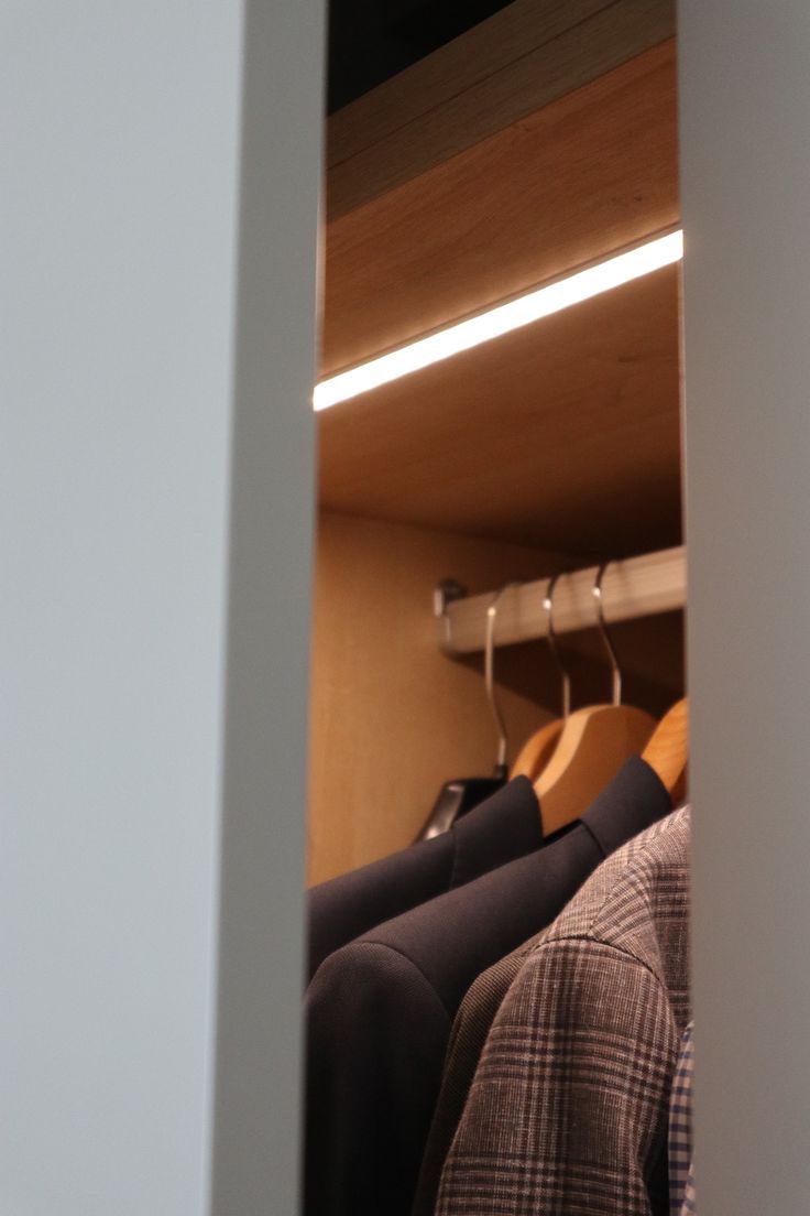 a closet with clothes hanging on hangers