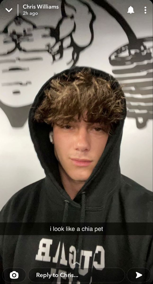 a young man wearing a black hoodie and looking at the camera