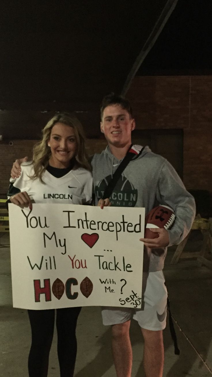 a man and woman holding a sign that says you interrupted my life, will you tackle hoo?