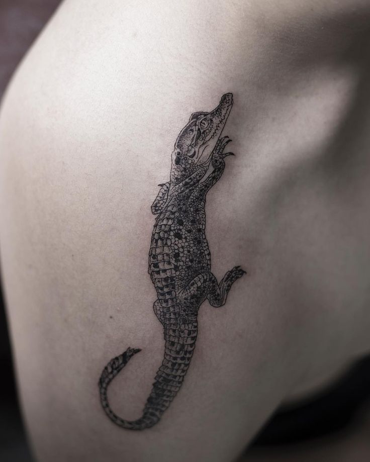 a black and white photo of a lizard on the back of a woman's shoulder