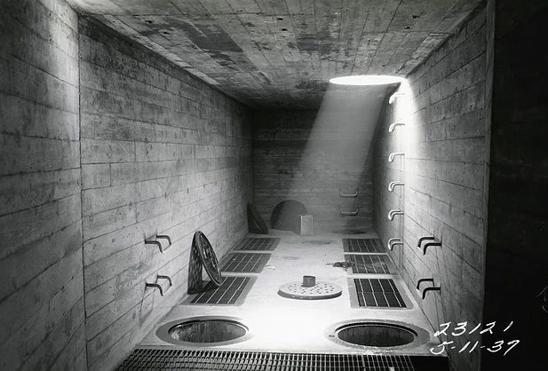 an empty room with several sinks in the floor and some lights above them on either side