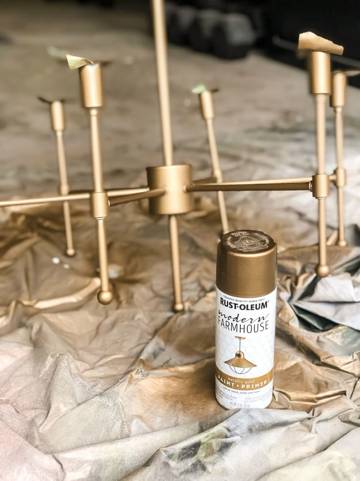 a spray bottle sitting on top of a table next to some gold candlesticks