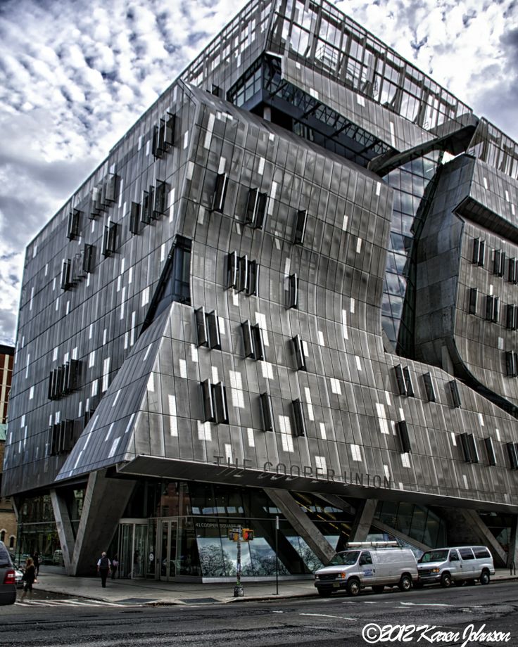 a large building with many windows on the side of it's face in front of a cloudy sky