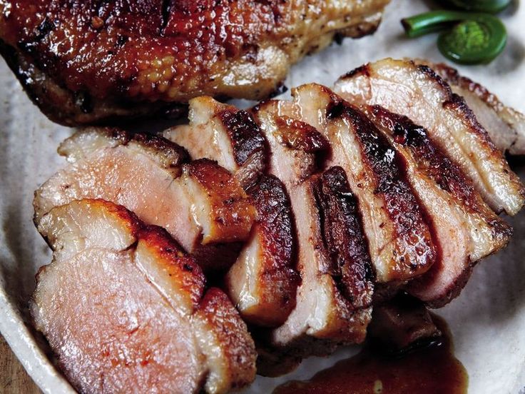 two pieces of meat sitting on top of a white plate