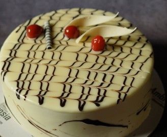 a white cake with chocolate icing and cherries on top