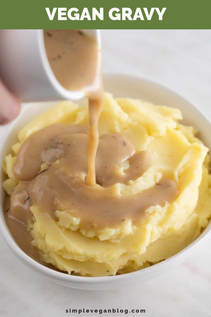 a bowl filled with mashed potatoes and gravy being drizzled on top