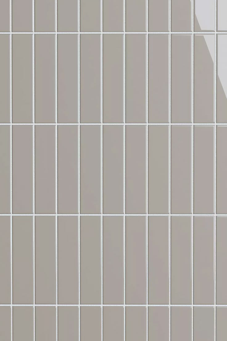 a white tiled wall with gray and white tiles