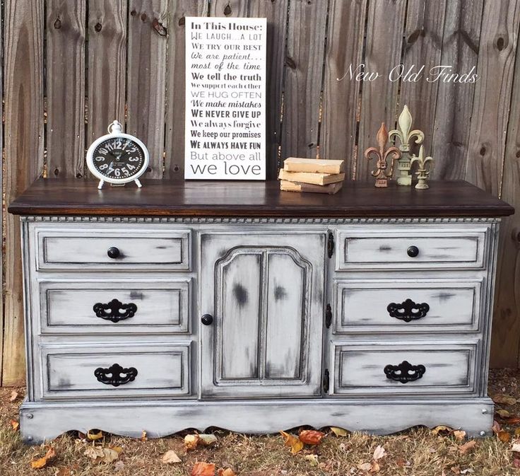 an old dresser is painted white and gray