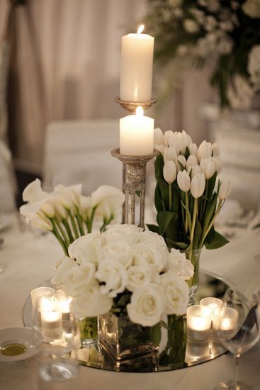 white flowers and candles are on a table