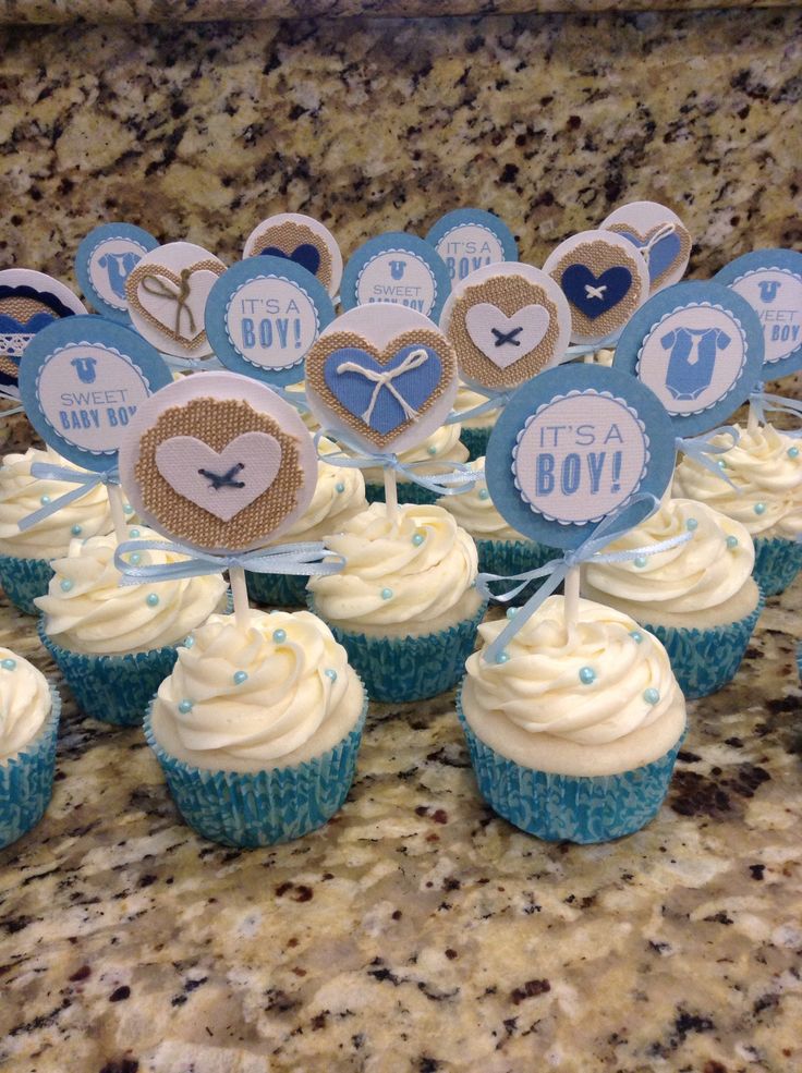 cupcakes with blue and white frosting sitting on a counter