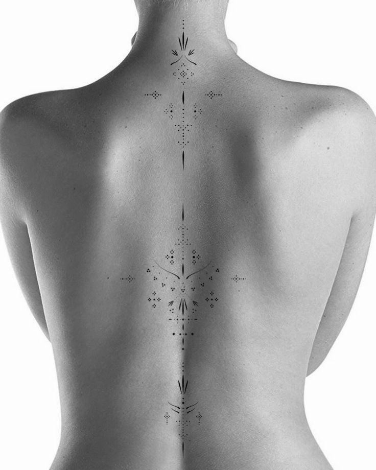 the back of a woman's body with tattoos on it