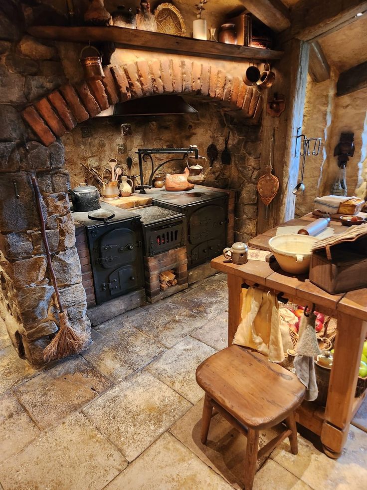 an old fashioned kitchen with stone walls and flooring is shown in this image, there are many pots on the stove