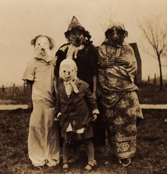 an old black and white photo of three people dressed up as clowns, one with a dog on his head