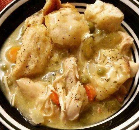 a bowl filled with chicken and dumplings on top of a table