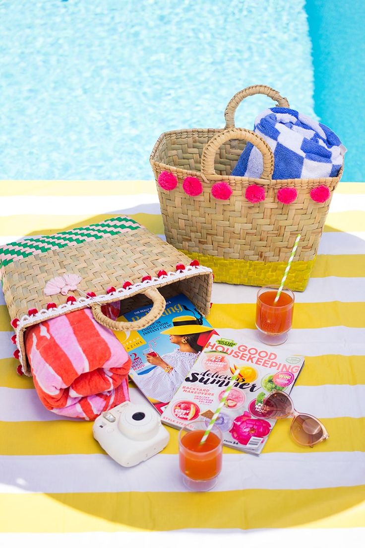 a picnic table next to a swimming pool with food and drinks on it, including an orange juice