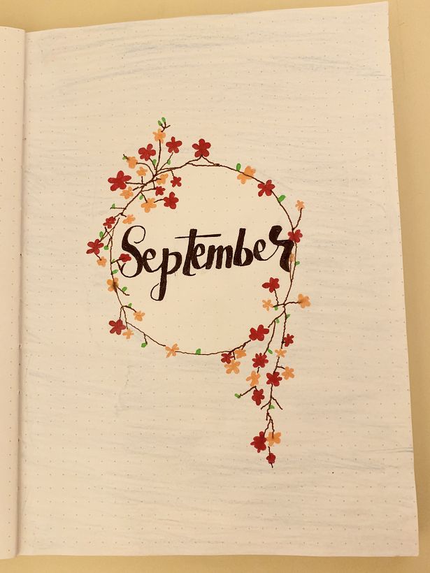 an open notebook with the word september written in it and flowers on each side of the page