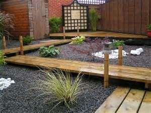 a wooden deck surrounded by gravel and plants