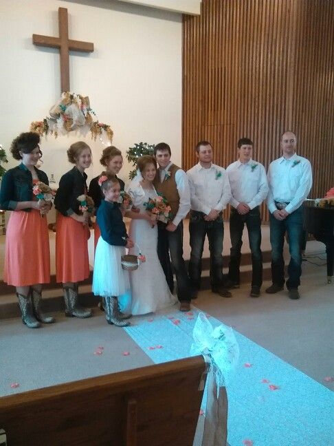 a group of people standing next to each other in front of a church pews