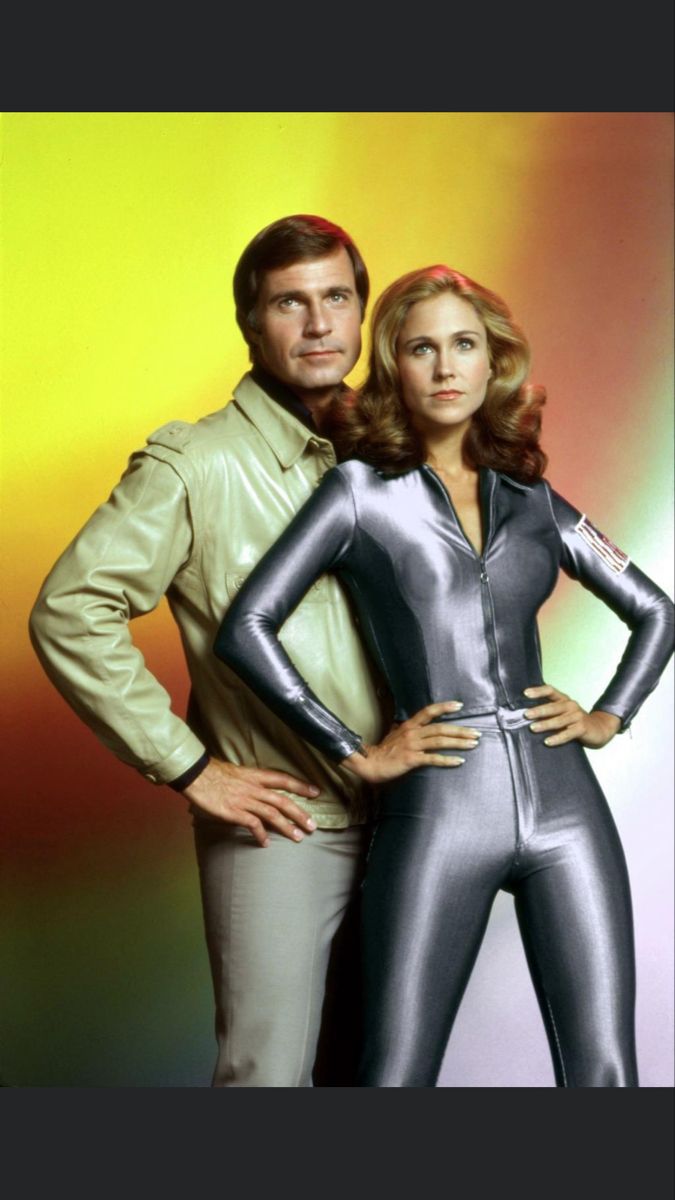 two people standing next to each other with their hands on their hipss and wearing shiny blue bodysuits