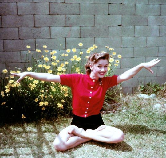 a woman sitting on the ground with her arms outstretched