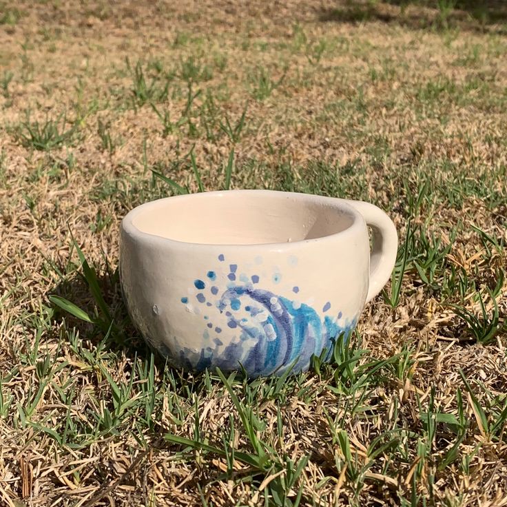 a white bowl sitting on top of a grass covered field