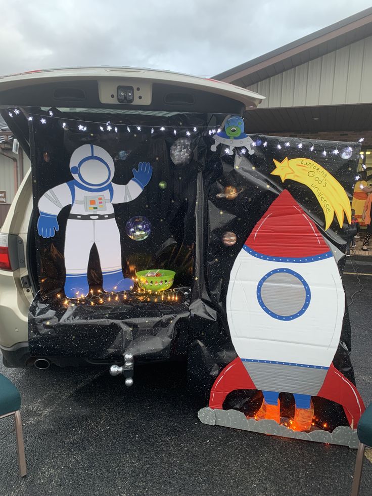 the back end of a vehicle decorated to look like a rocket ship and man in space suit