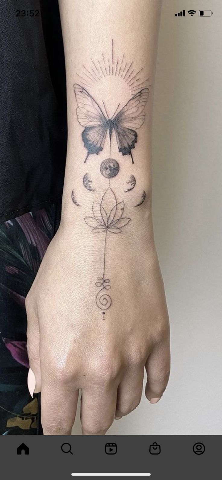 a woman's hand with a butterfly tattoo on it