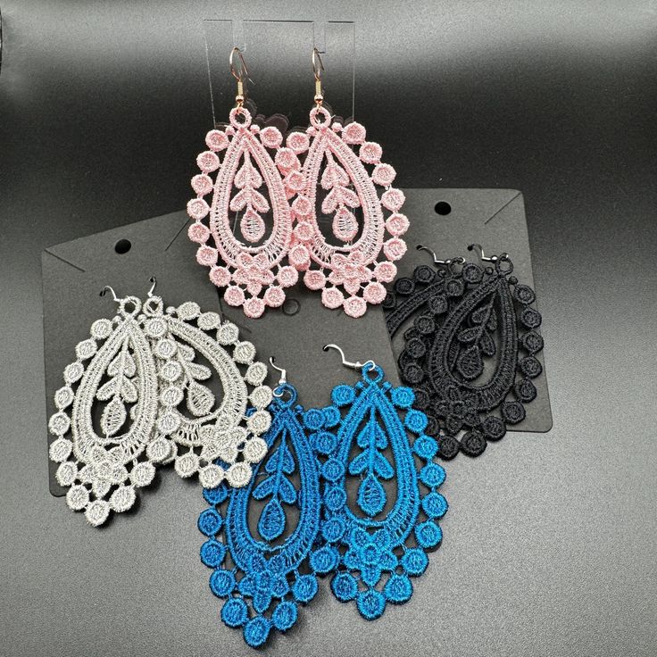 three pairs of earrings are sitting on a table next to each other and one is made out of crochet