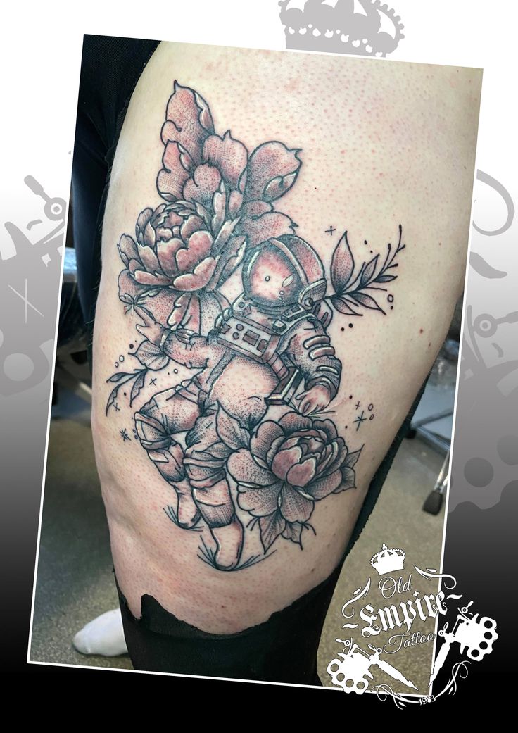 a woman's thigh with flowers on it and a motorcycle helmet in the middle